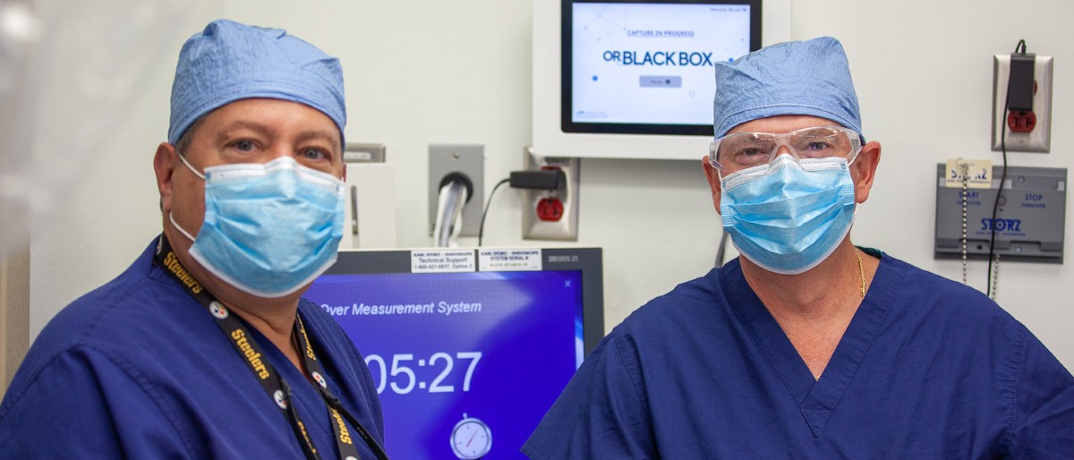 Dr. Herbert Zeh (left) and Dr. William Daniel stand in front of the OR Black Box control screen.