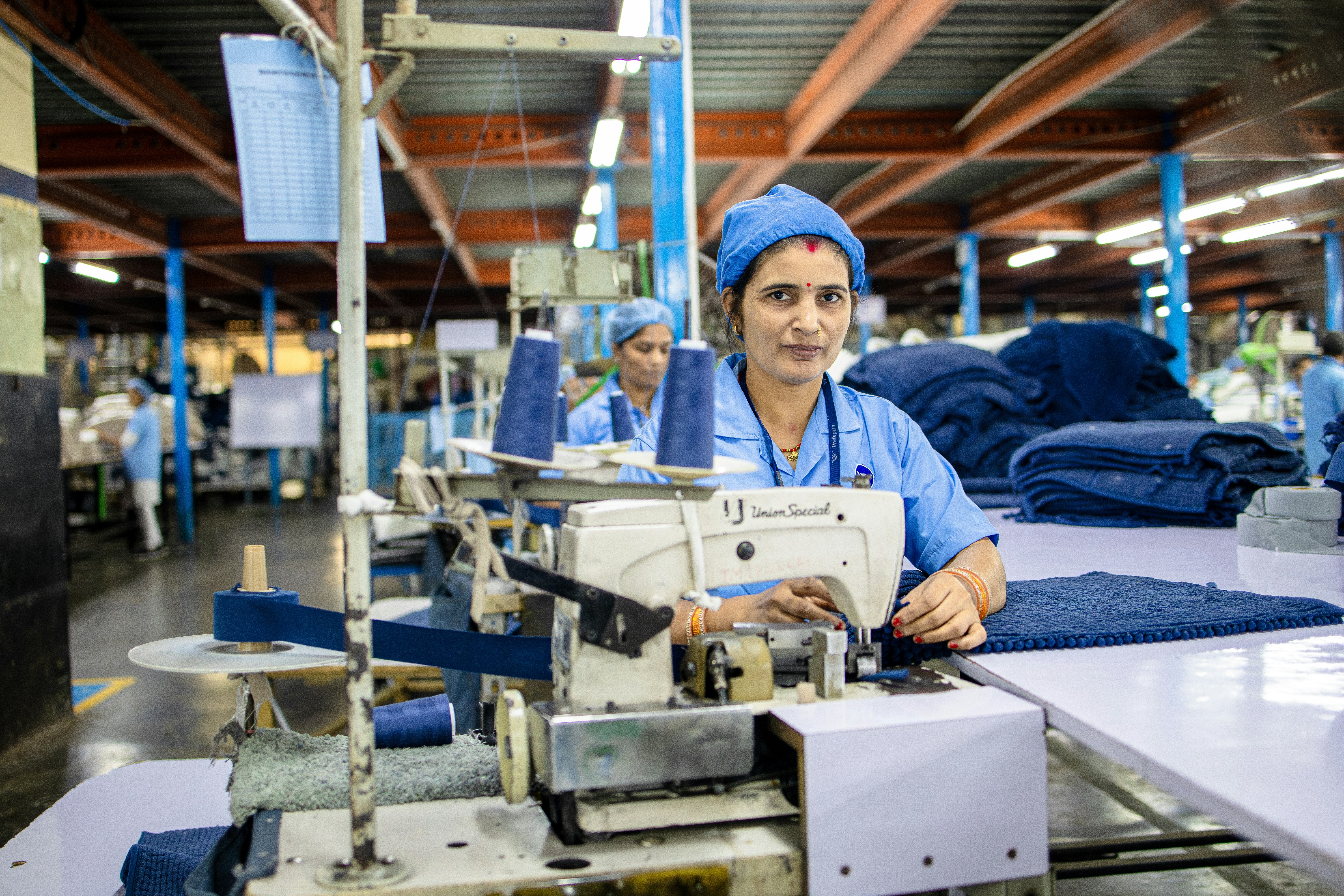 Woman sews clothes at a textile factory.