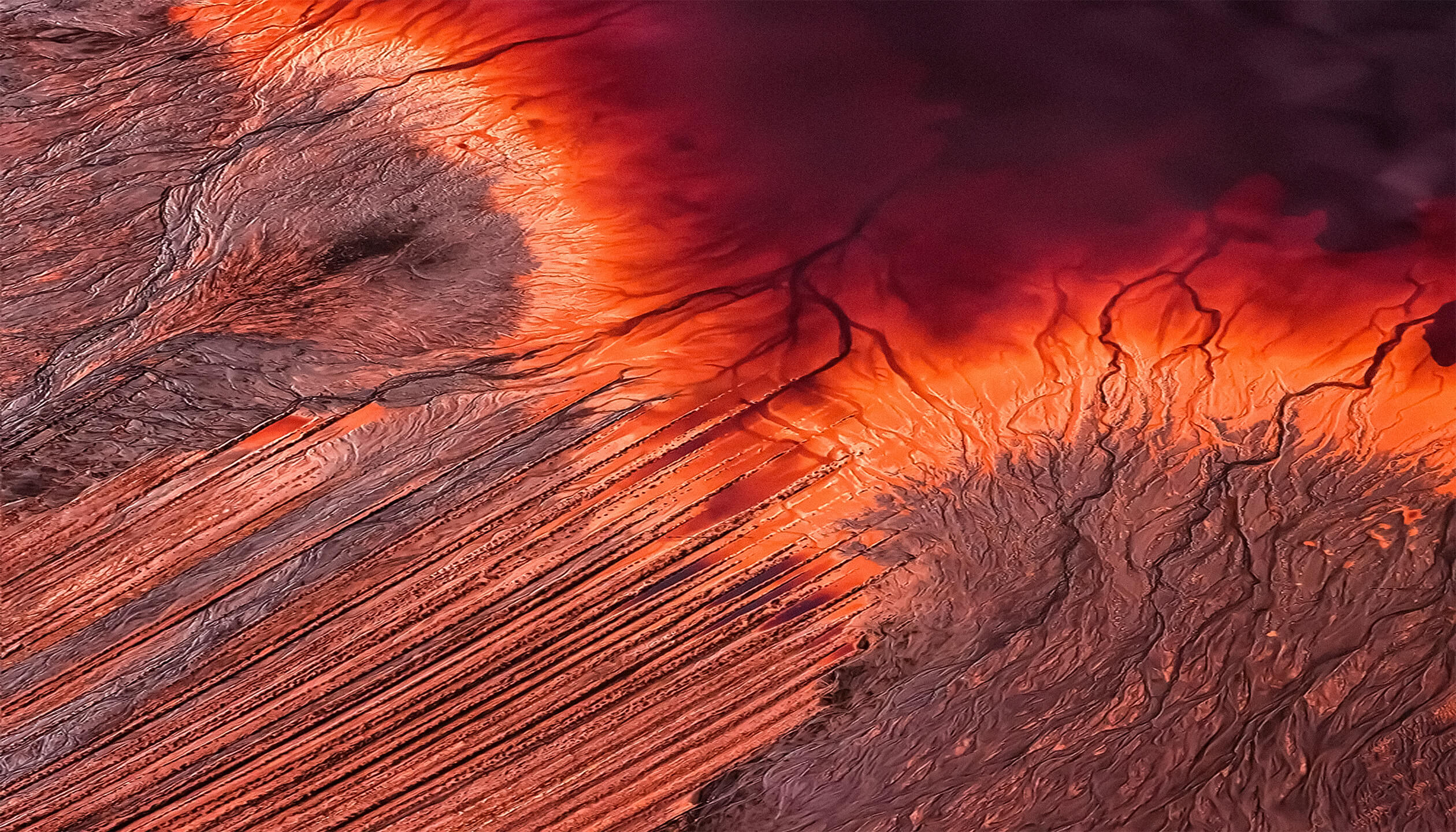 Aerial view of mineral-rich terrain in orange and red tones