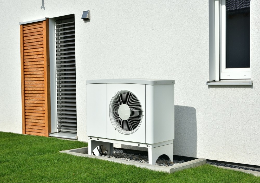 A white air source heat pump outside of a building