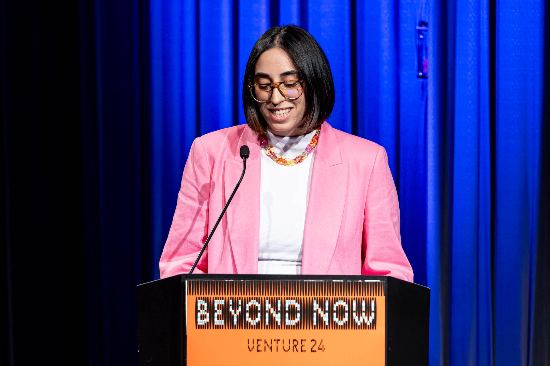 a student at a podium presenting a project in a Theatre