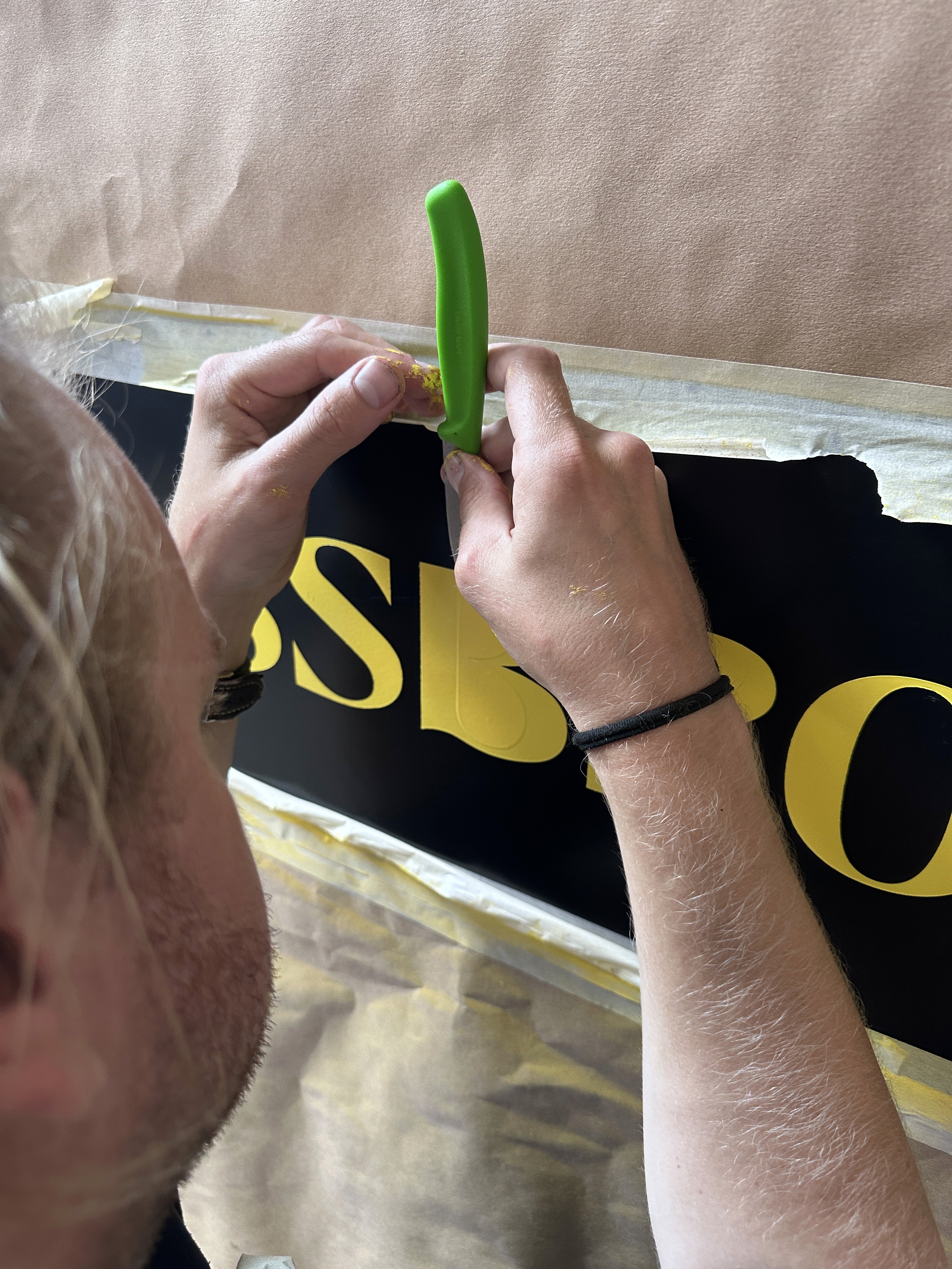 The storefront of a clothing boutique with large stone pillars and a concrete facade