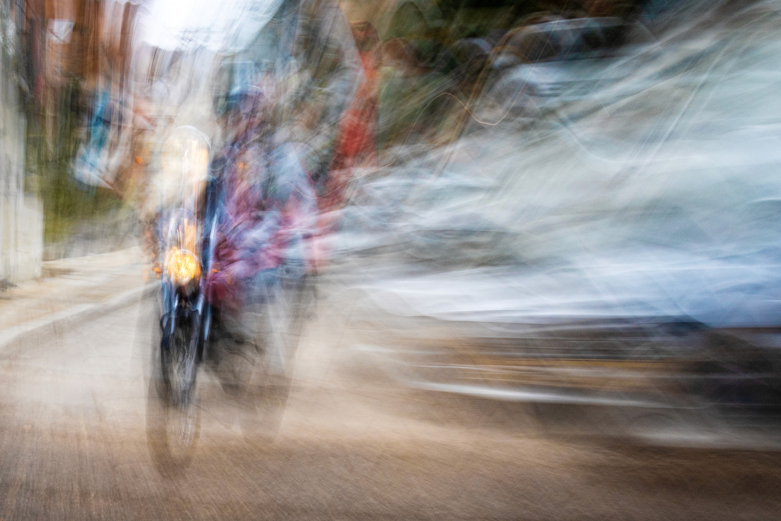 A person riding a bicycle through a colorful street, with motion blur suggesting speed and excitement.