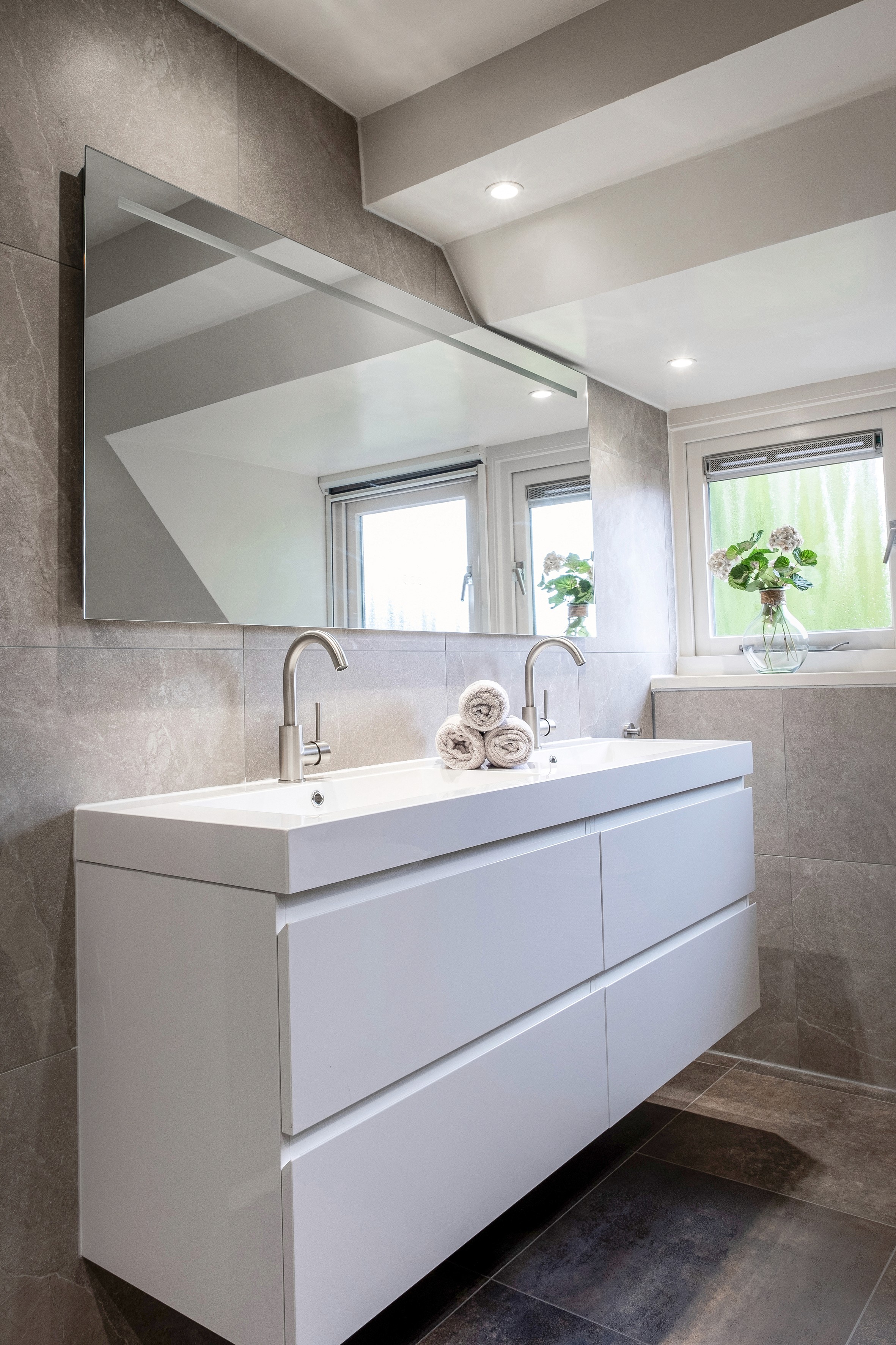 Stijlvolle badkamer met warme kleuren en geïntegreerde verlichting – ideaal voor high-end renovatieprojecten.