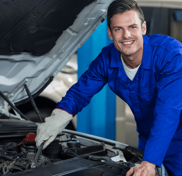 Smiling mechanic repairing engine.