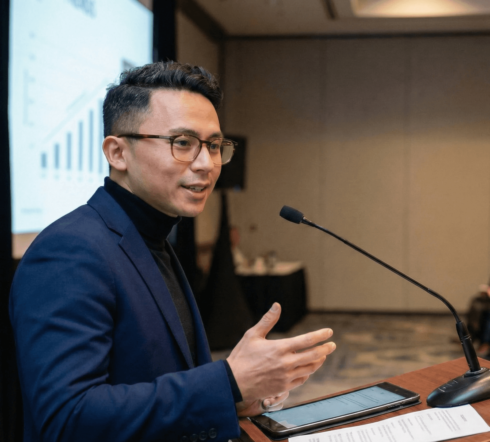 Four diverse professionals collaboratively working on a laptop, with one person pointing at the screen while others observe.