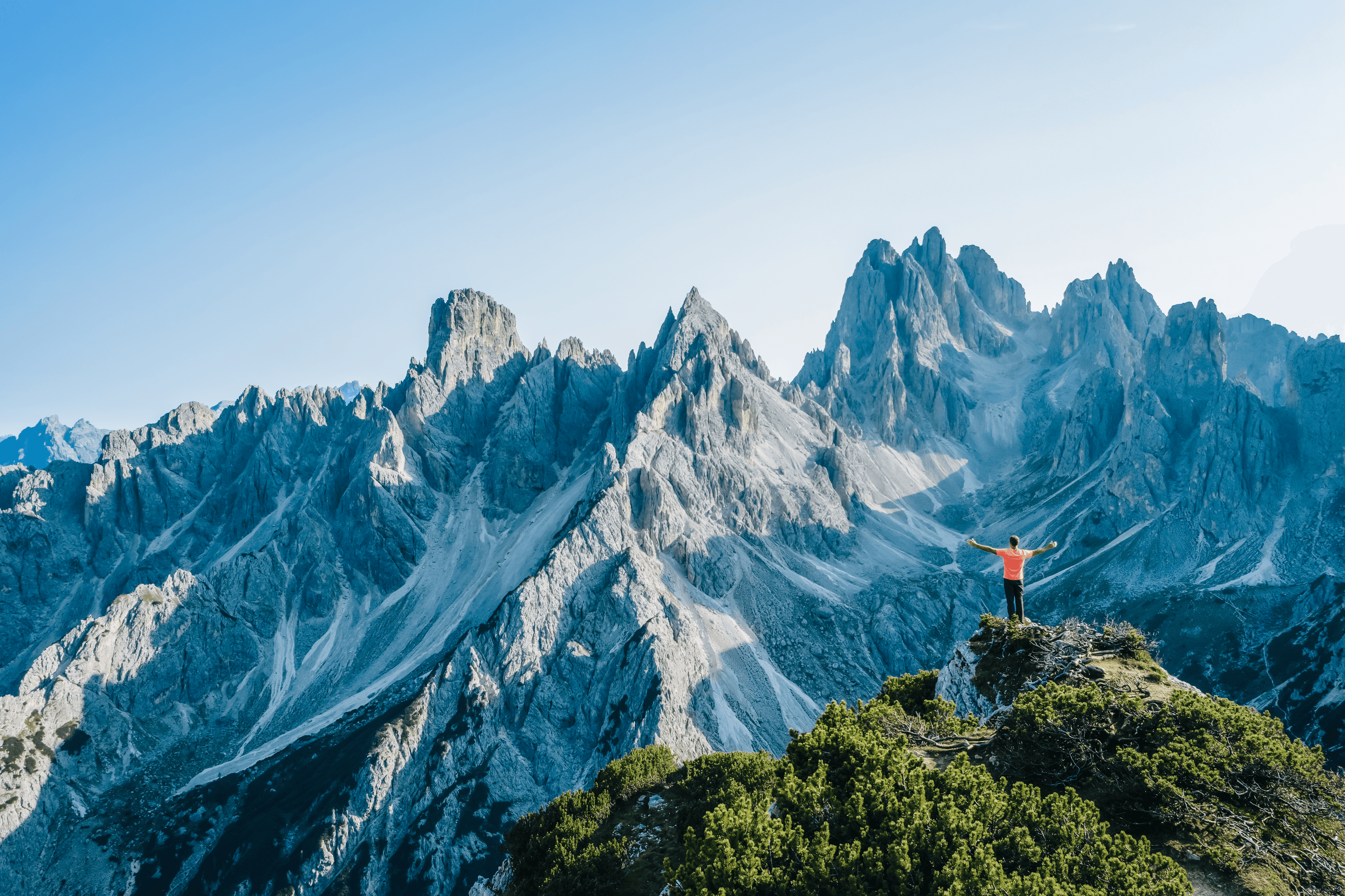 man raising hands in the mountains of italy
