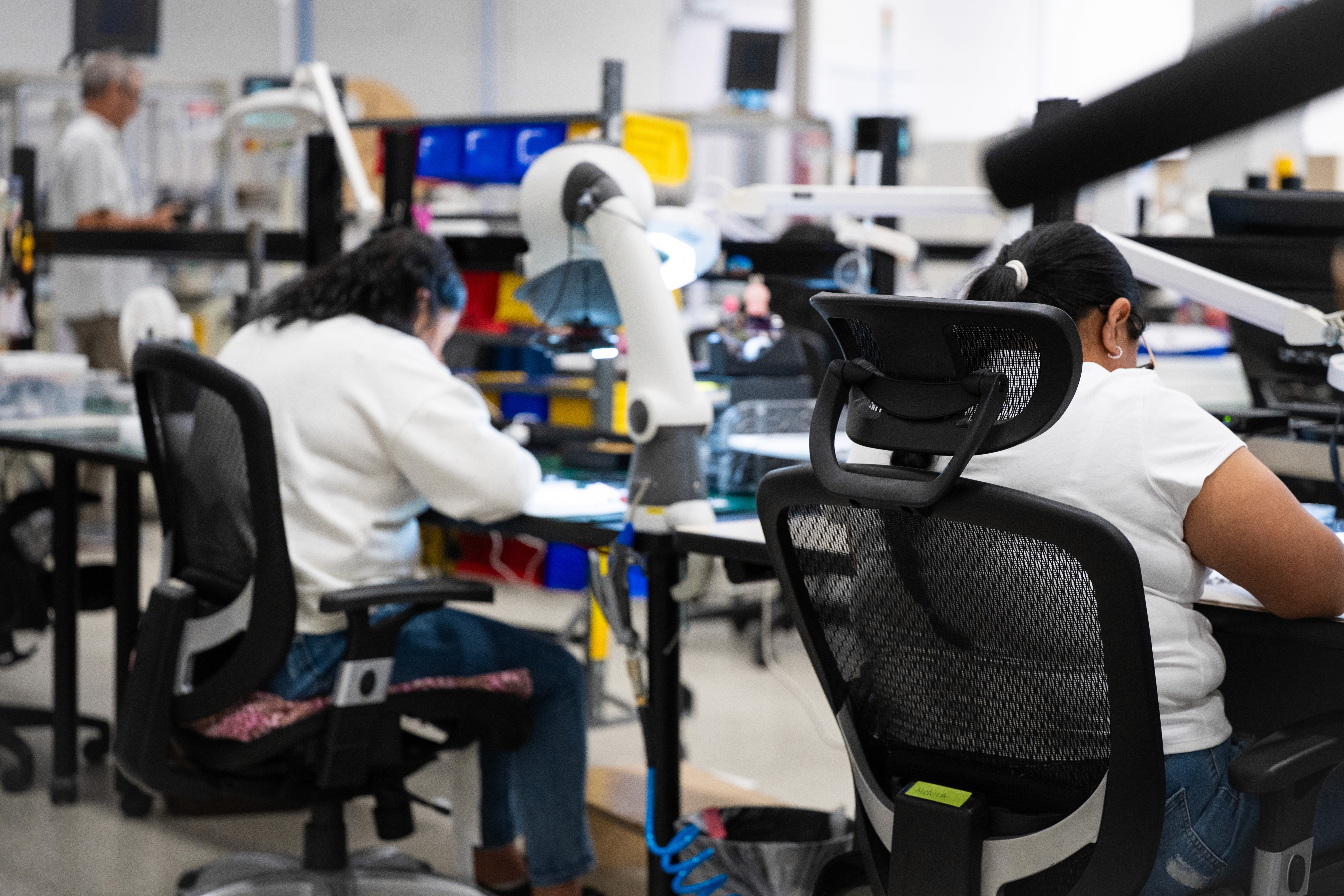 two women workers are seen doing detail work at a chip manufacturing facility in Texas.