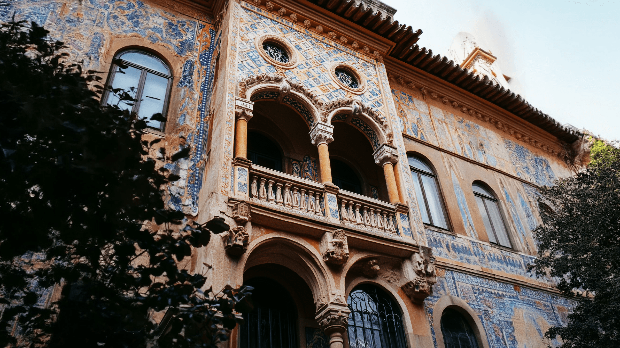 Historic building facade with intricate architectural details, featuring balconies and decorative elements.