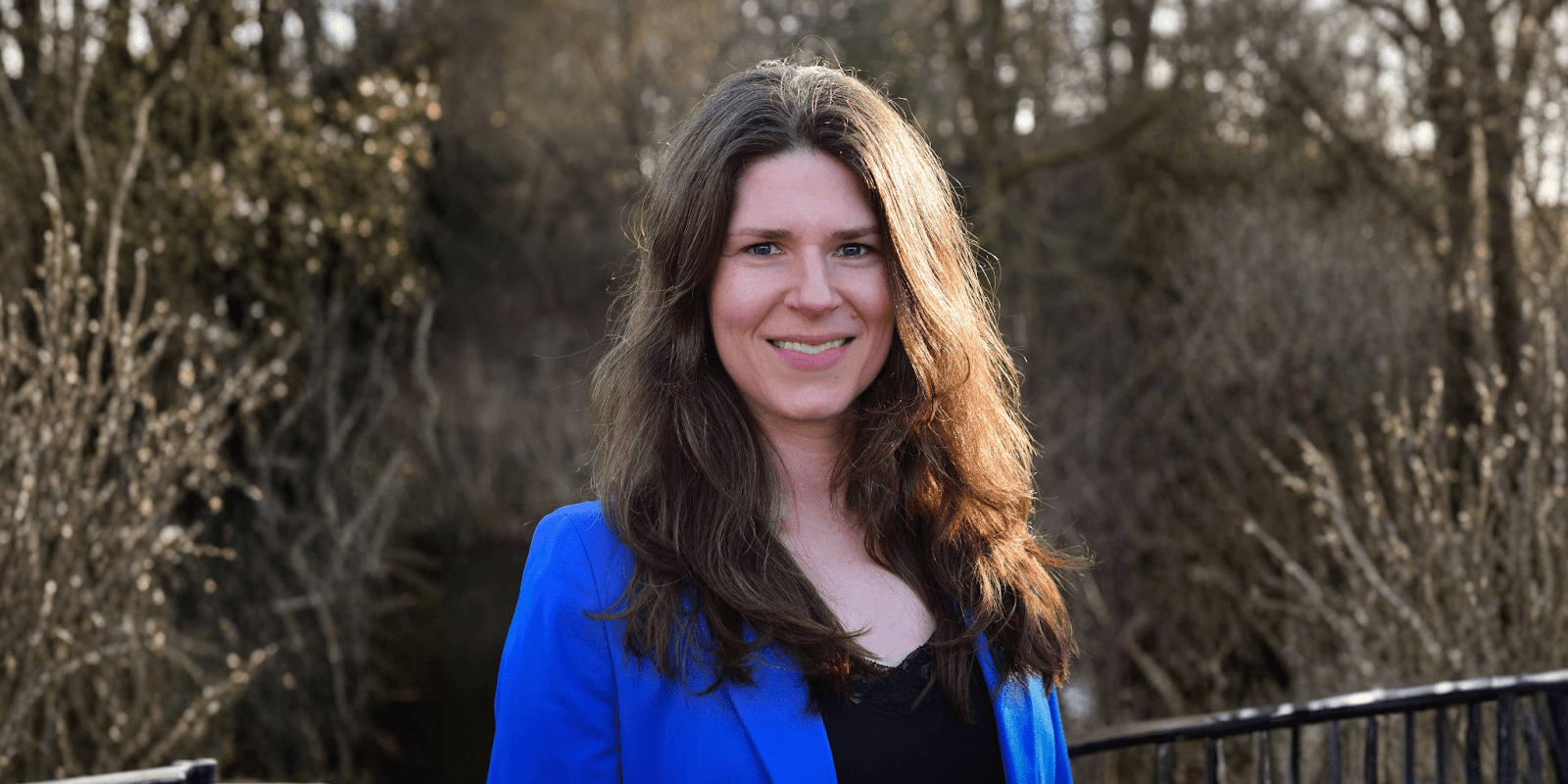 Ellen Duffy-Lueb, a women’s leadership strategist, smiling confidently in a blue blazer, advocating for burnout prevention and energy management.