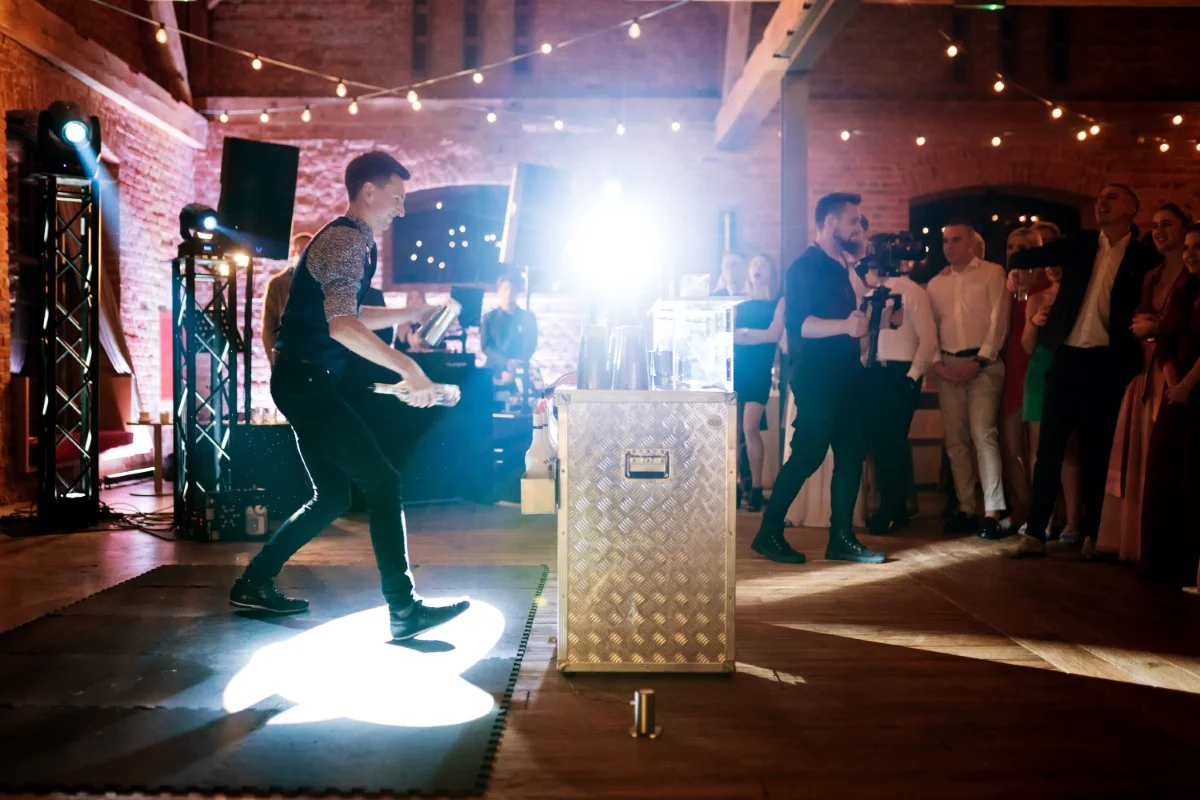 Atrakcje weselne – barman wykonuje pokaz barmański na mobilnym barze.