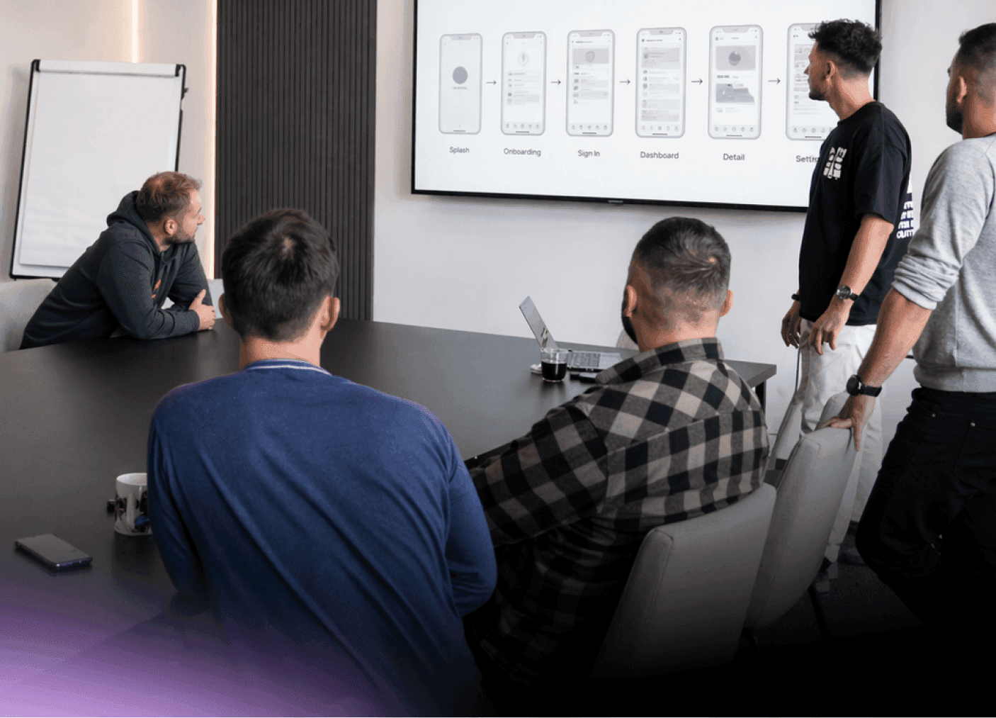 Nextio product team reviewing mobile app wireframes and user flow on a large screen during a strategy session.