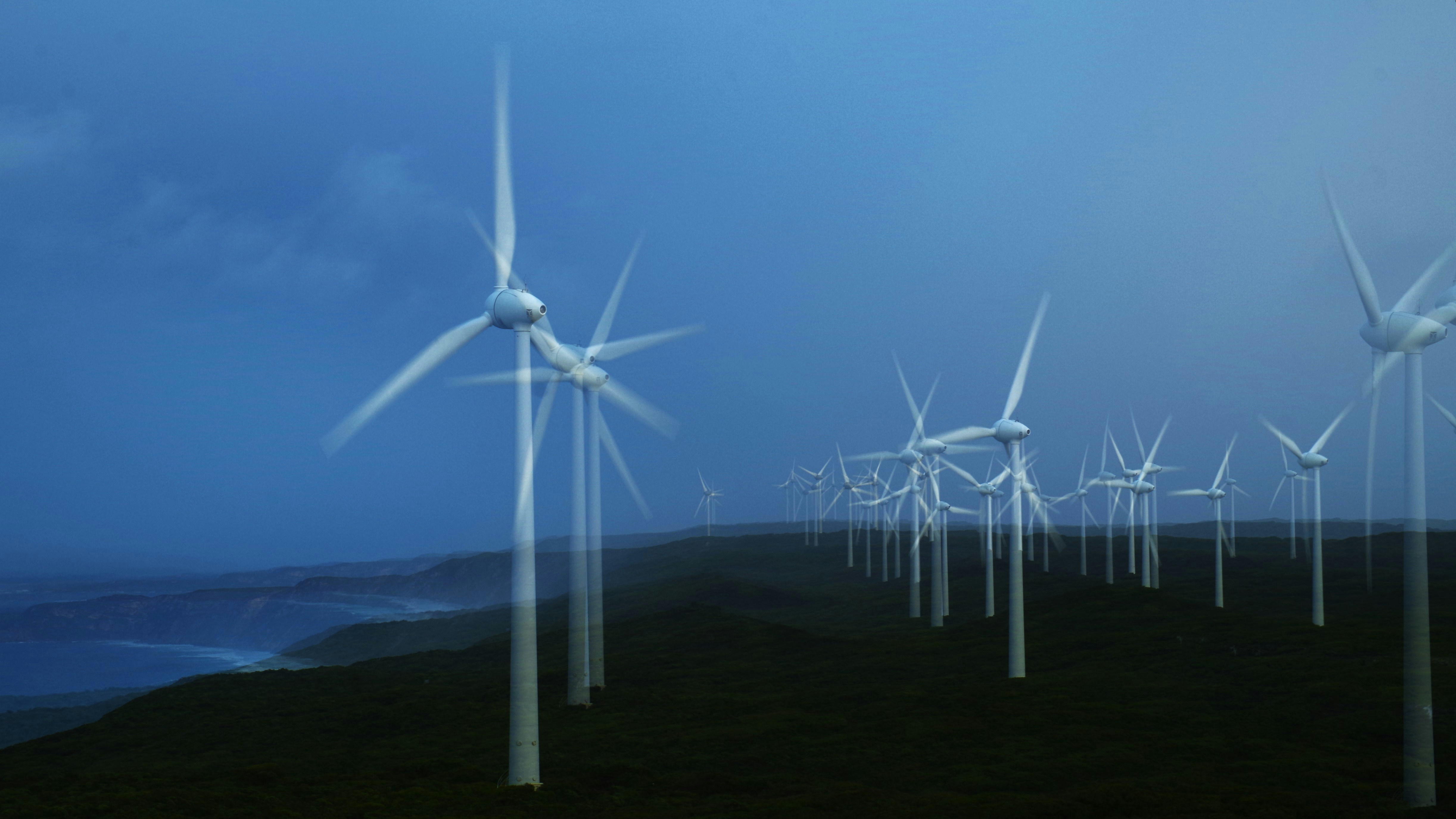 Wind turbines generate clean energy on a dark day.