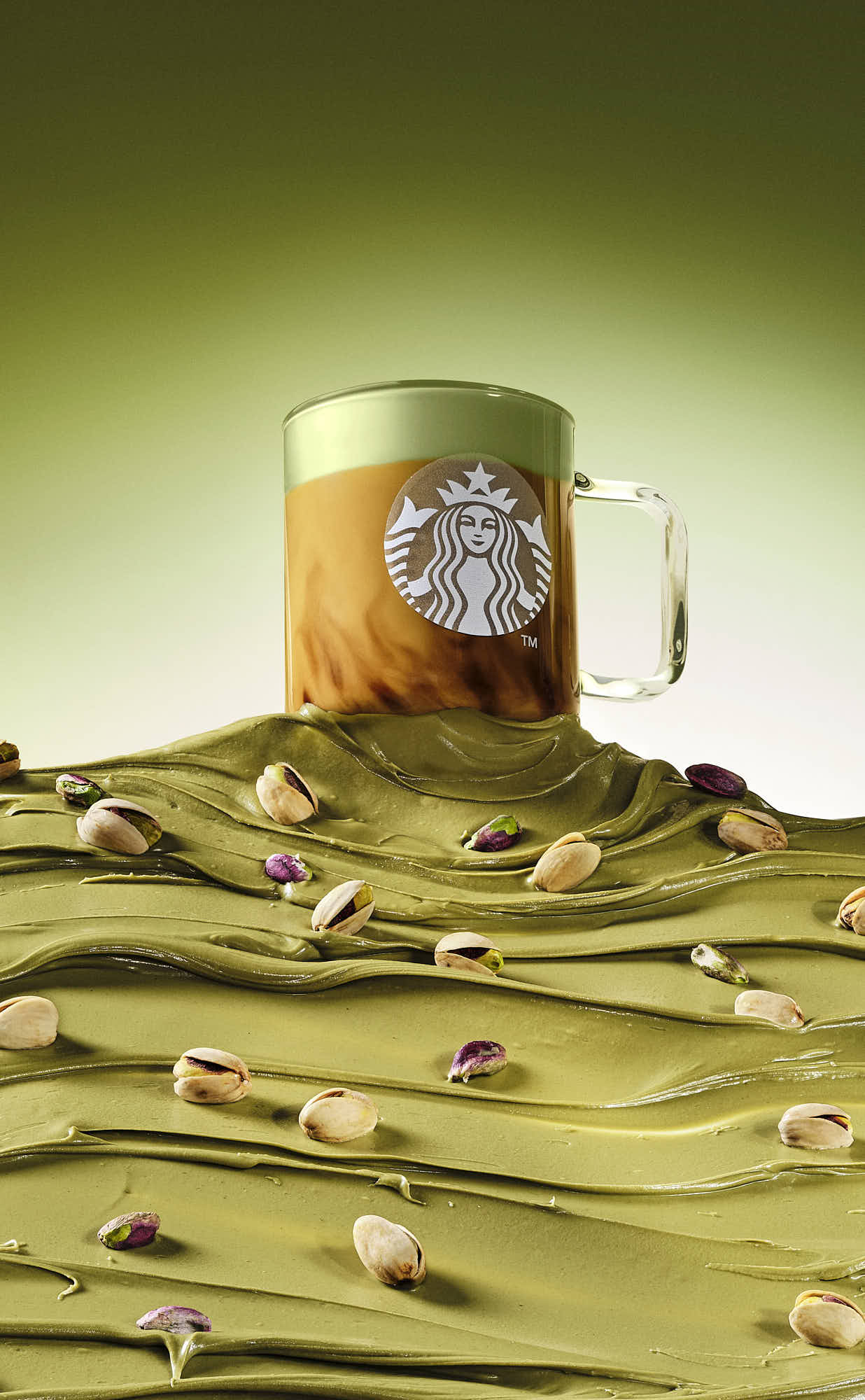 A heroic image of a coffee latte partially buried in golden p, with a soft green background.