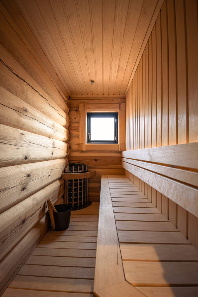 "Compact wooden sauna with bench seating inside a 72 sqm log cabin.