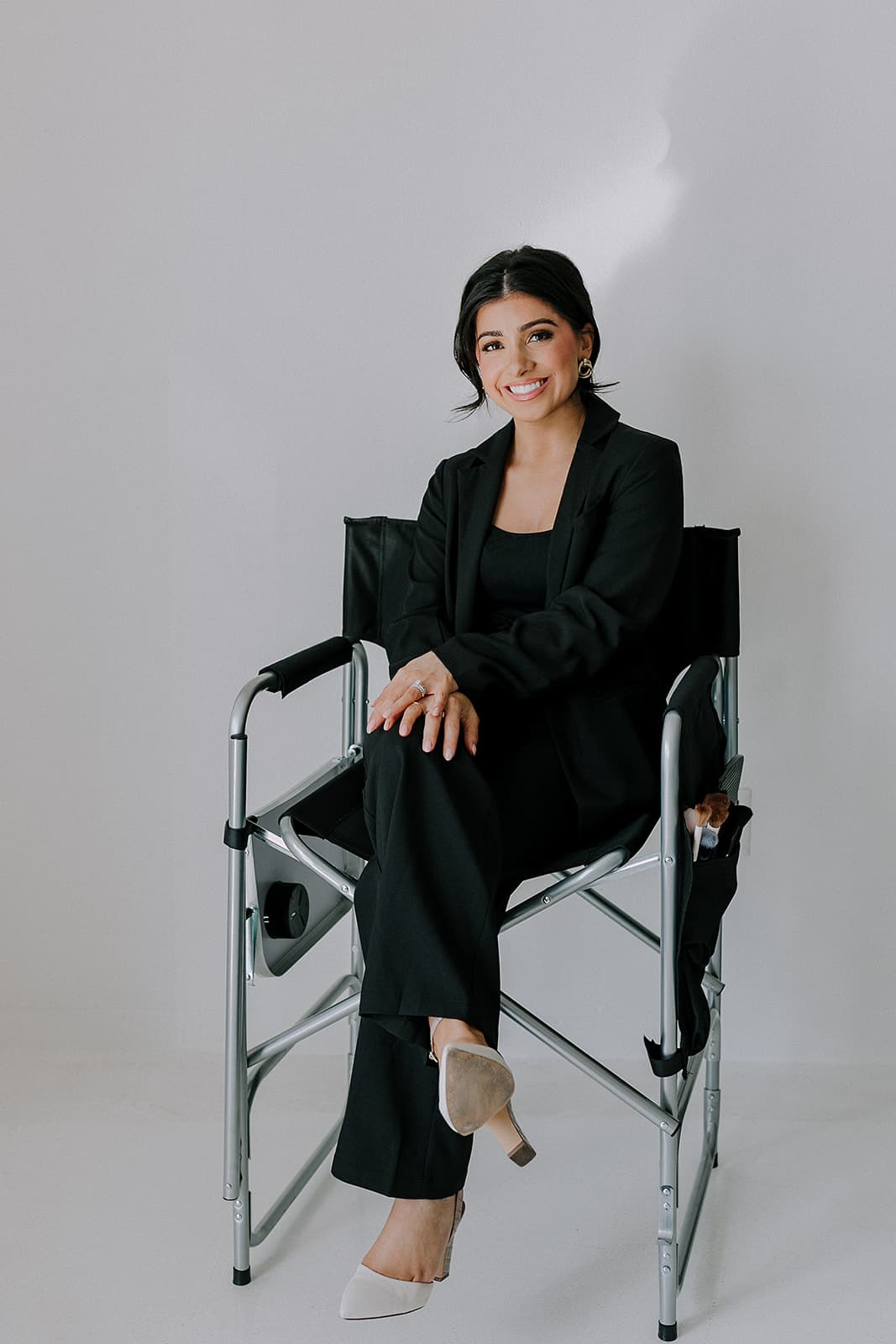 Haley Gould sits in a makeup chair, ready for her professional photo session at Revelator Studio, a premier natural light studio in Shreveport.