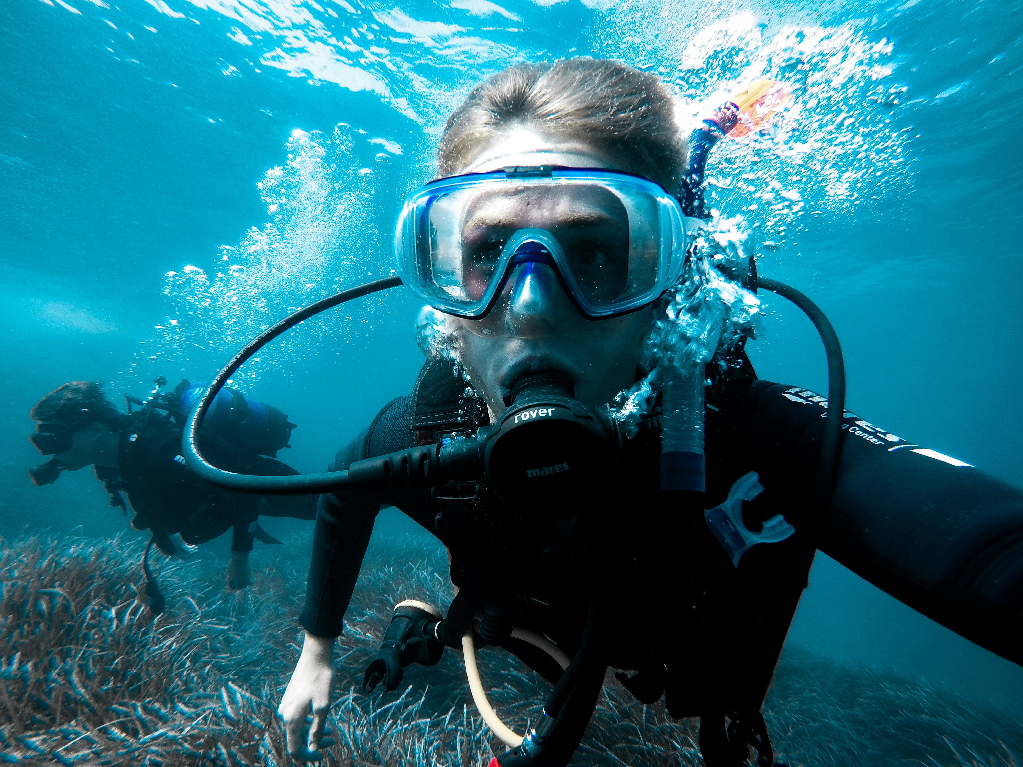 person in black and white diving suit wearing goggles