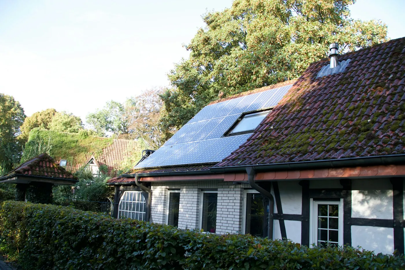 Einfamilienhaus mit fertiger Photovoltaikanlage auf dem Dach bei sonnigem Wetter