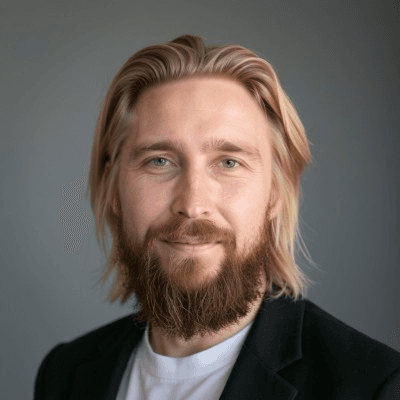 Black and white portrait of a smiling person with curly hair