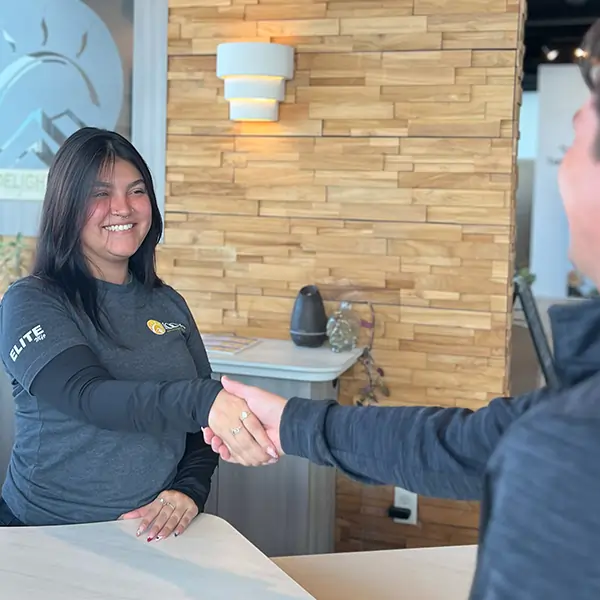Receptionist greeting patient as they walk into Wellness clinic.