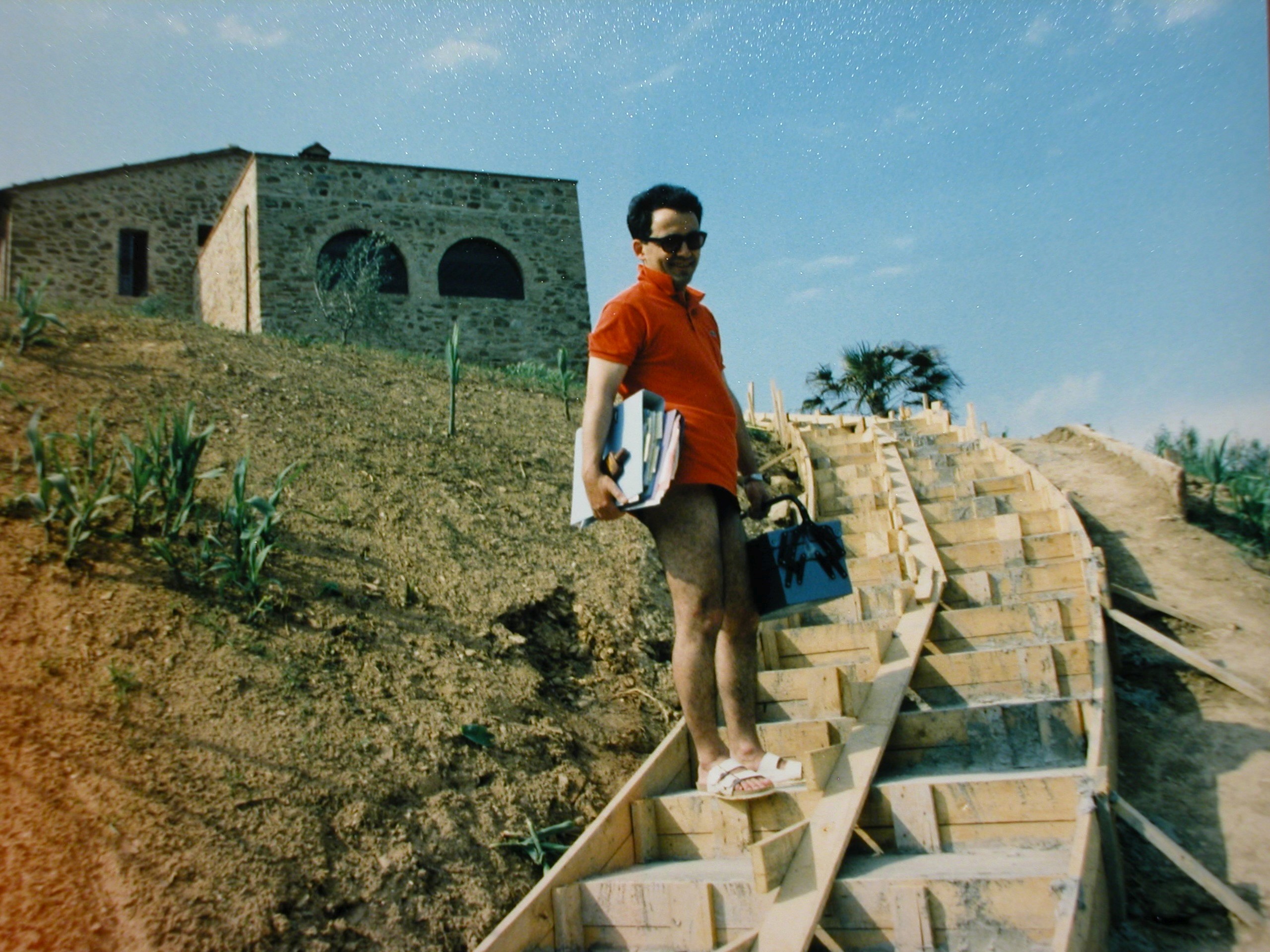 Woman in a light suit sitting thoughtfully against a terracotta wall