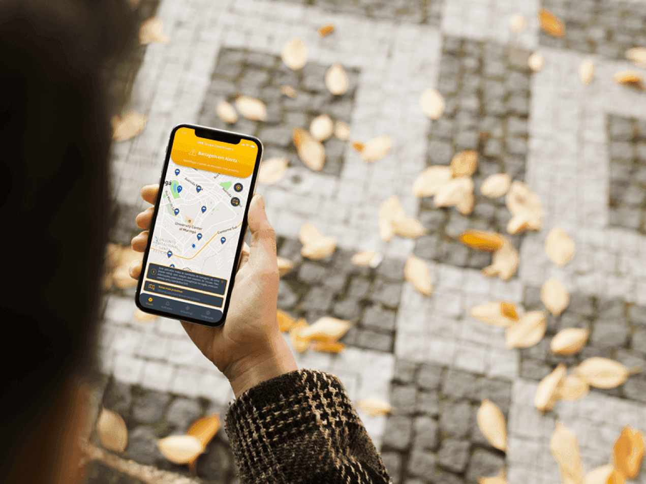 Fotografia de uma pessoa segurando um celular exibindo a UI do App Alerta Individual