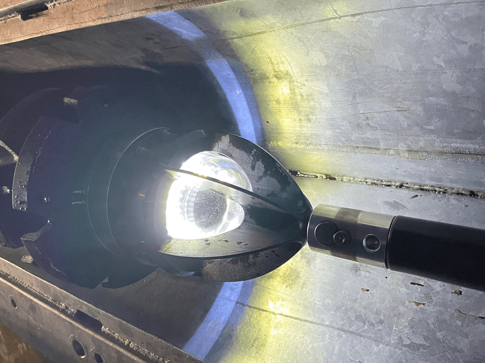 ReadyCAM camera head illuminated inside a metal conduit during inspection