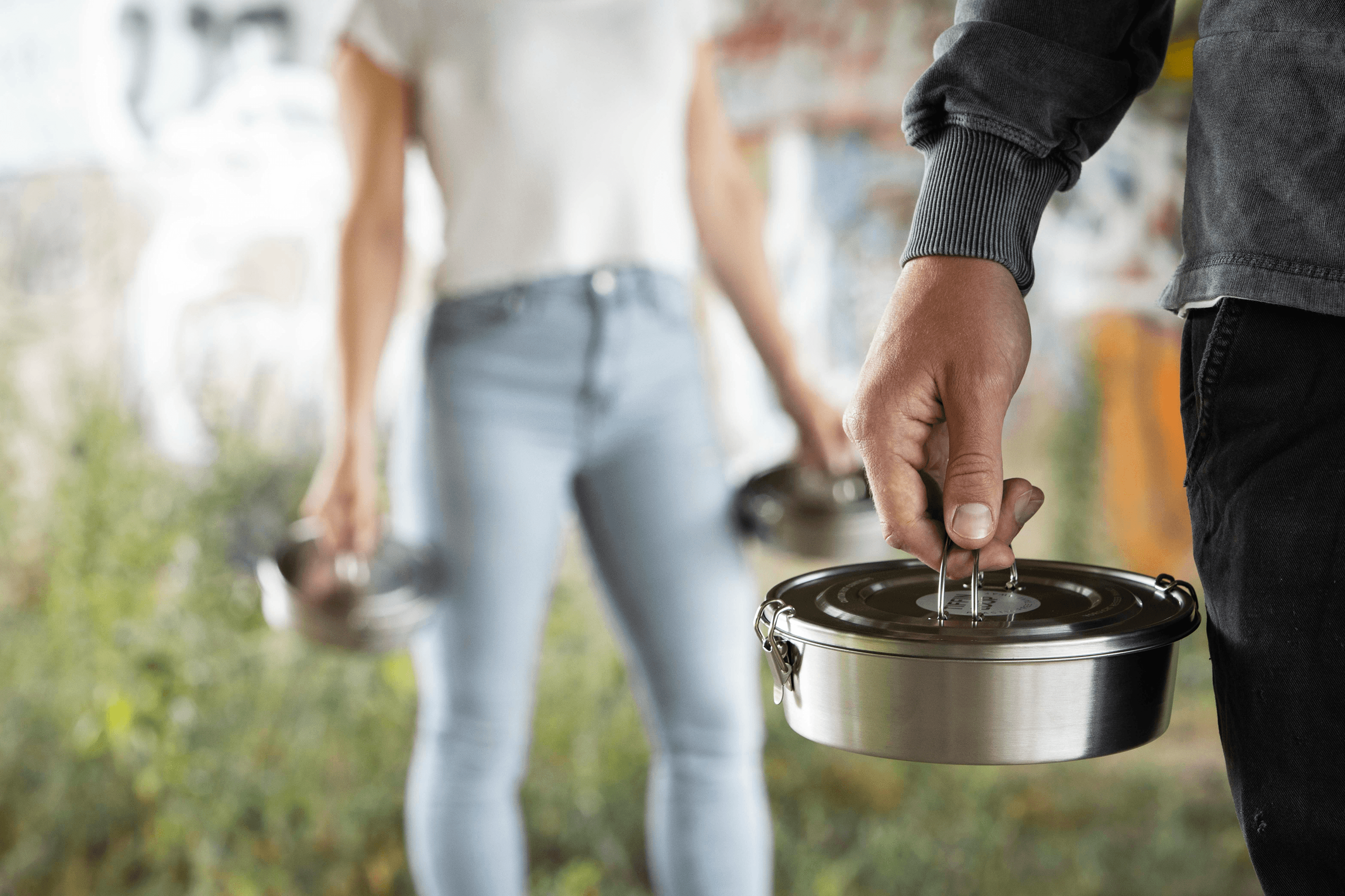 Hand holding a metal tiffin container
