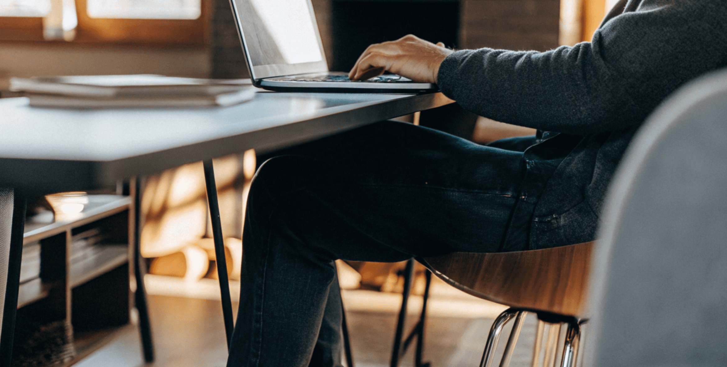 Man typing on laptop at contemporary desk