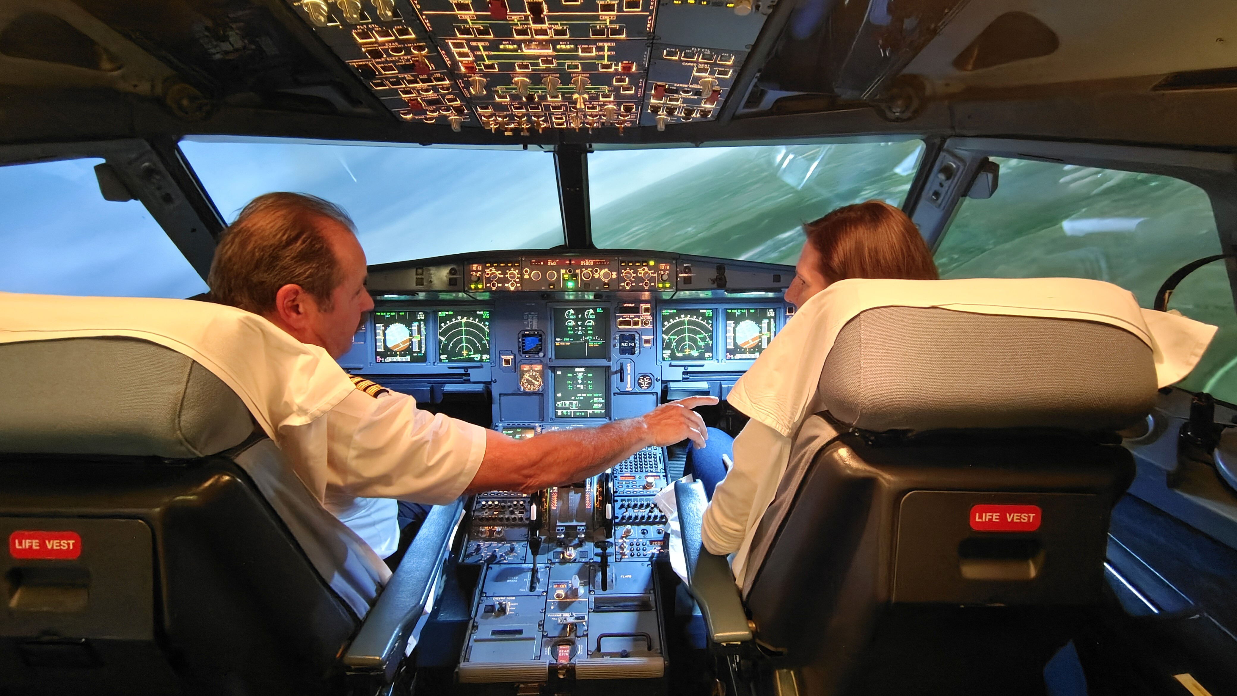 Pilot with course participant inside simulator