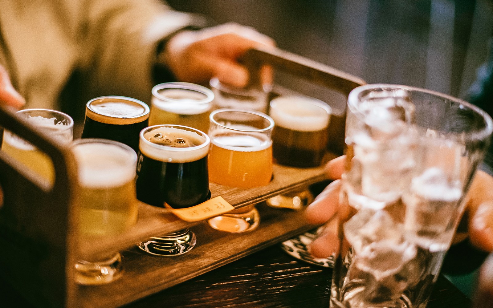 Degustare de bere artizanală pe un suport de lemn în timpul turului de pub-uri din Busan.