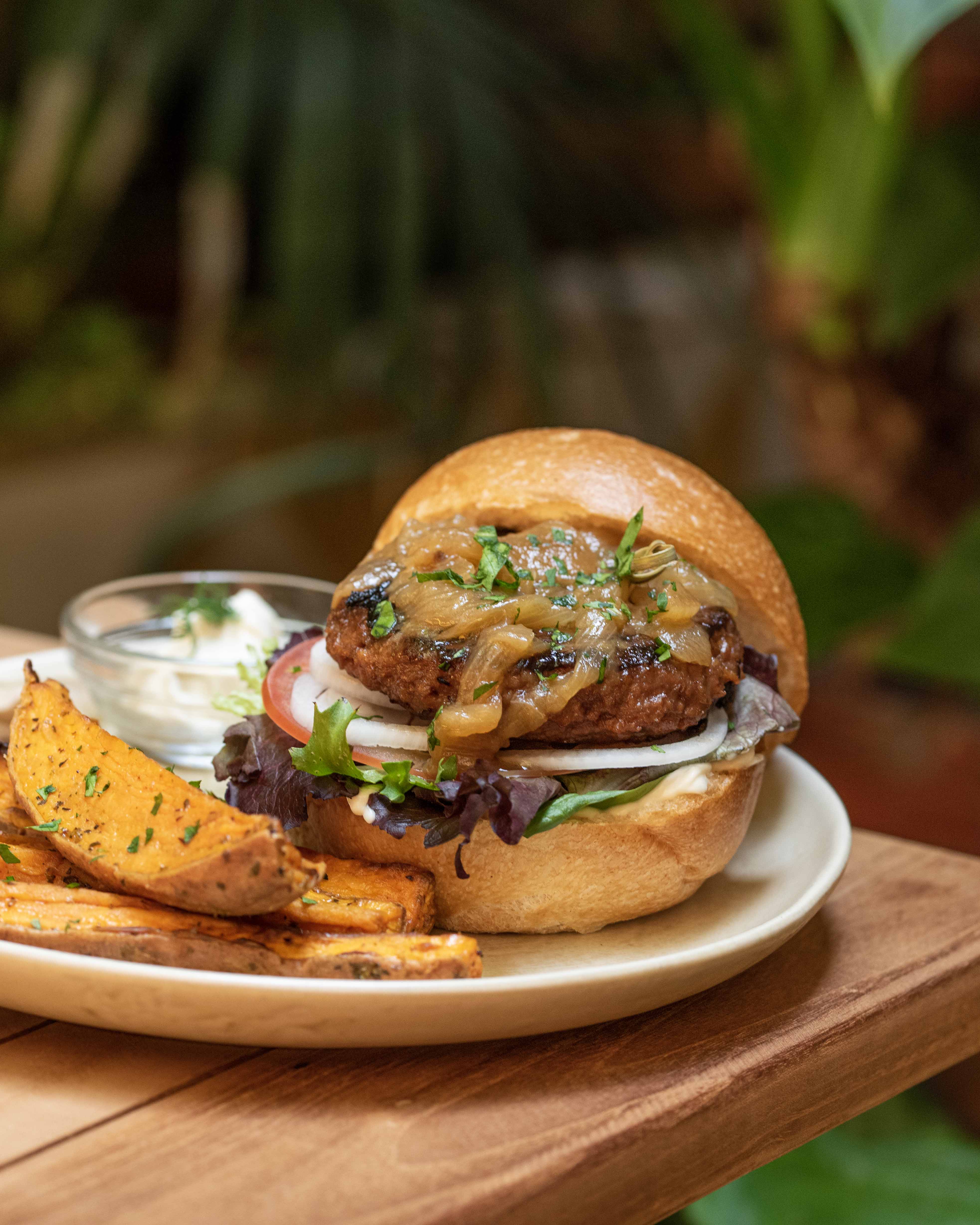 Vegan burger with caramelised onion and sweet potato wedges at Faire. Brunch & Drinks