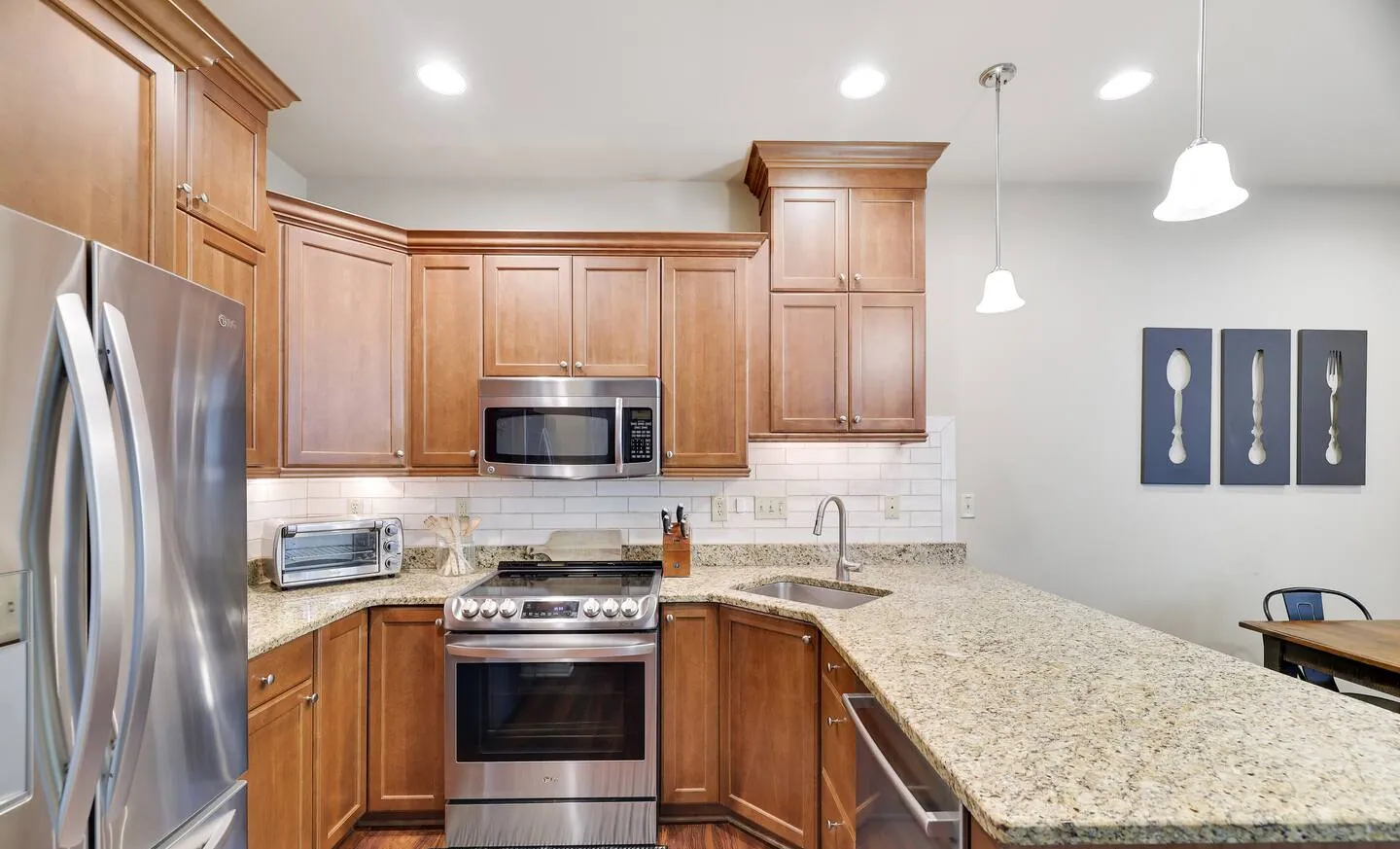 Kitchen with stainless gas range, granite counters and pendant lights at Mountainwoods Memories