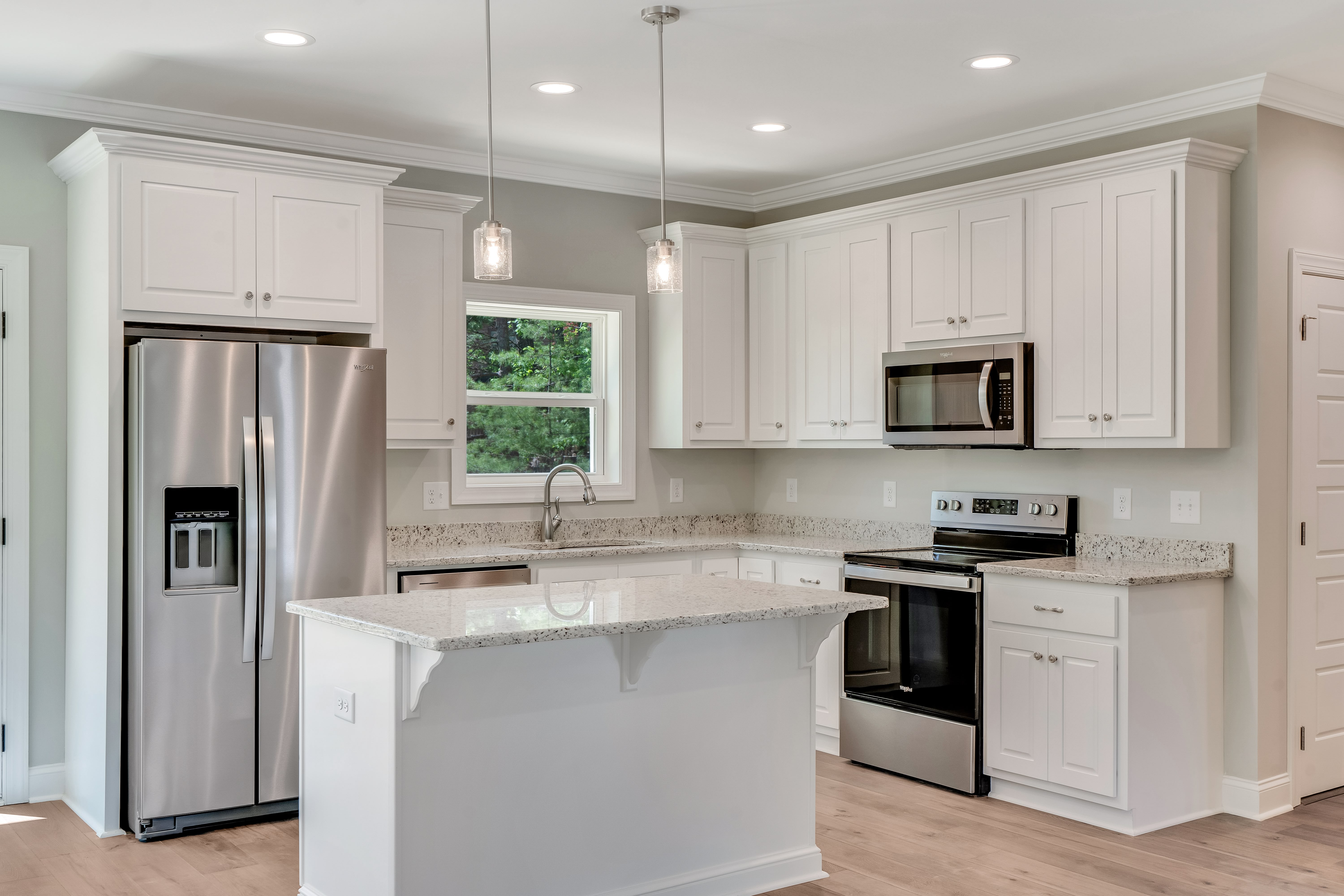 Open concept kitchen and living room with vaulted ceilings and hardwood floors