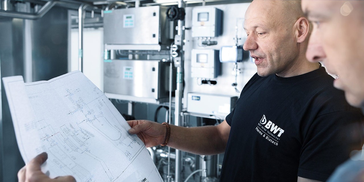 Two people working and holding paper