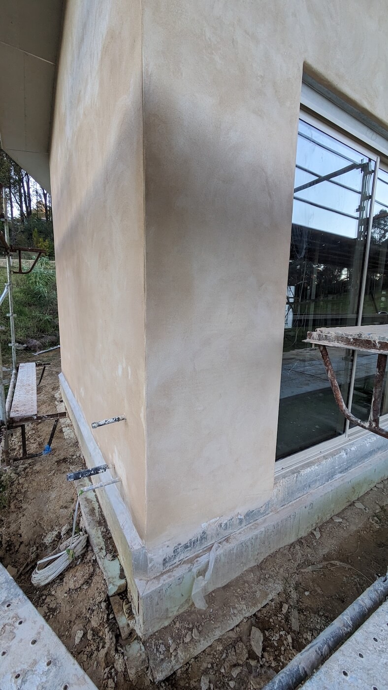 A partially finished hempcrete wall featured in the house.