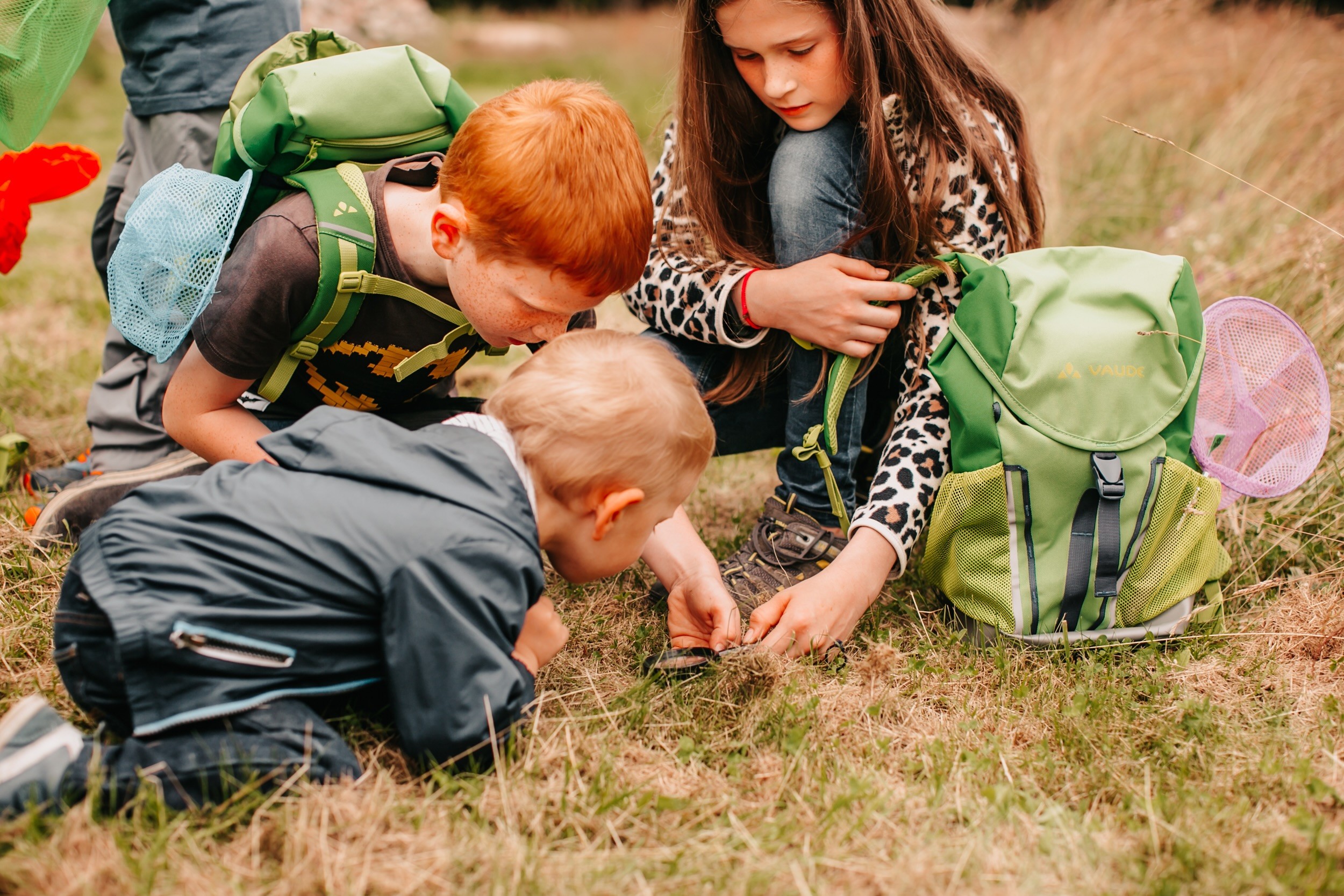 three children with the green backpack from Vaude