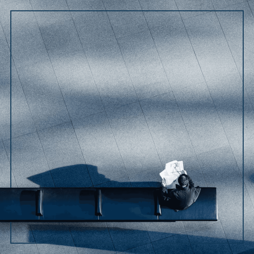 Ein Mann sitzt auf einer bank, aufgenommen aus der Vogelperpektive