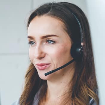 A female, wearing headsets and responding to customer IT questions on the call.