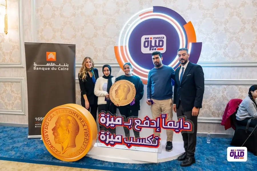 Prize-giving group portrait beside the Meeza display and Banque du Caire branding