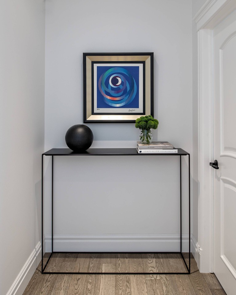 Image of Console table with decorative items and framed art in a modern interior design setting by KHD Homes.