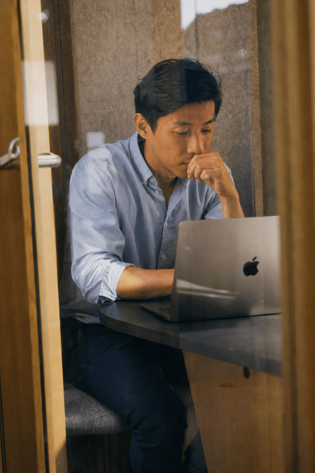 Reviewing the buyer conversation on one open Mac in a small office booth.