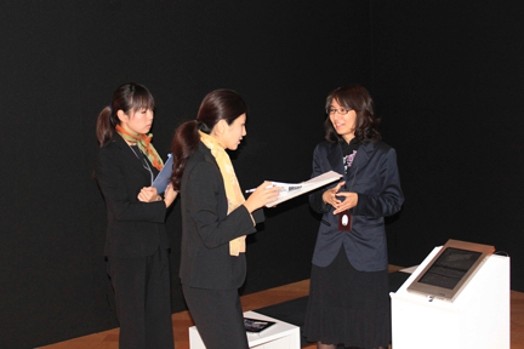 Three women dressed in black are talking