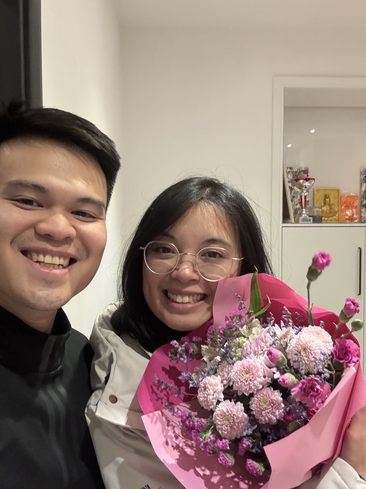 A bride and groom share a kiss, enveloped in the bride's flowing veil. The soft focus and gentle light convey a romantic, intimate atmosphere.
