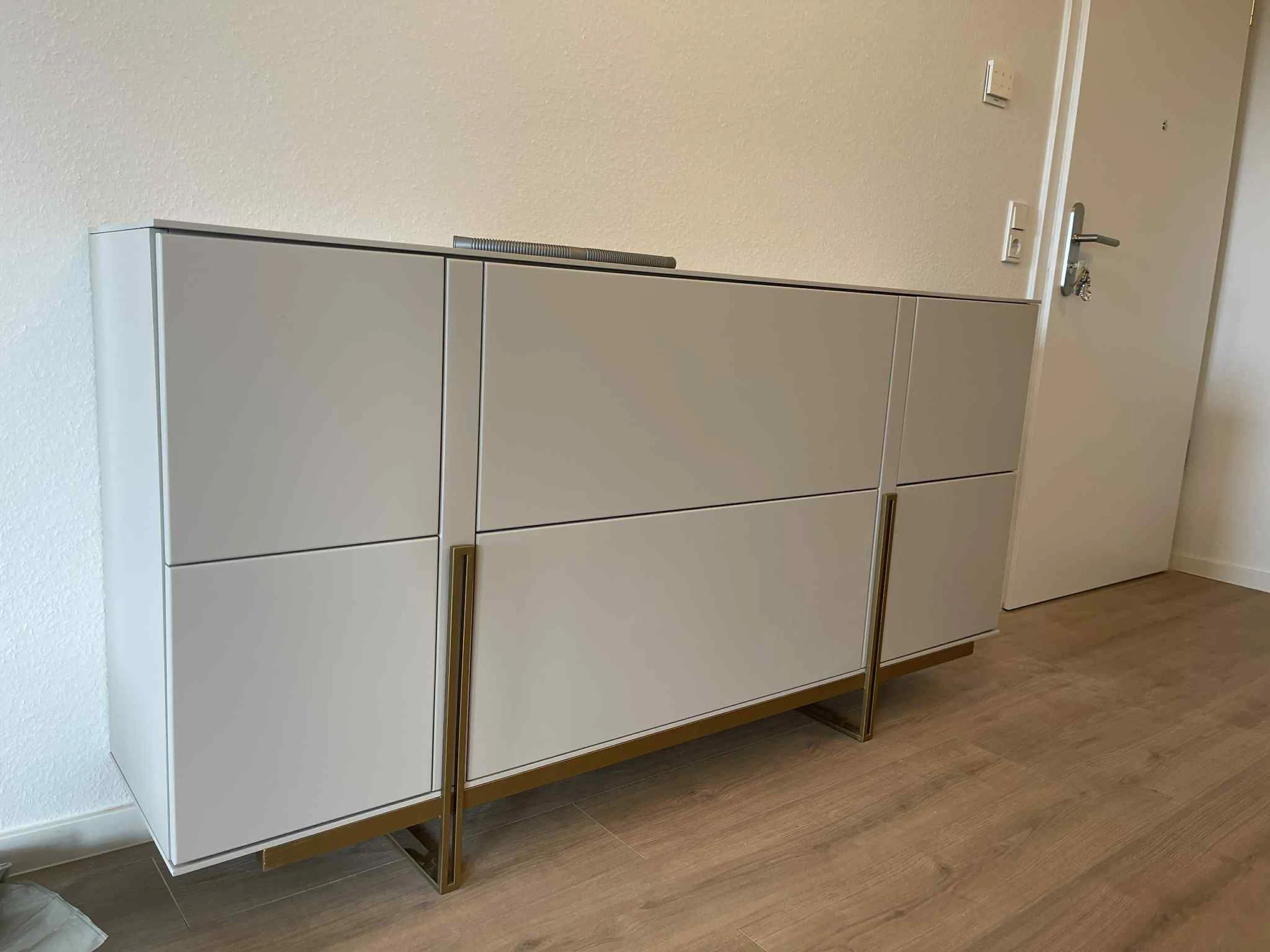 Buffet sur mesure laqué mat avec piétement et poignées effet laiton — fabrication et pose au Luxembourg.