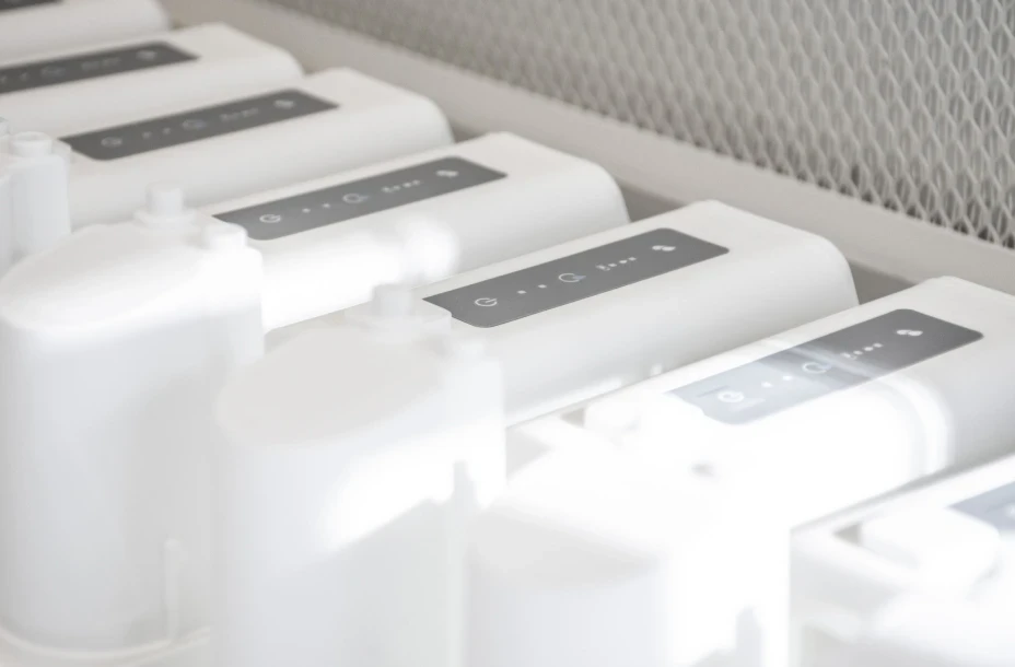 White Cutitronics devices aligned in production testing rig, demonstrating medical device hardware assembly and quality control.