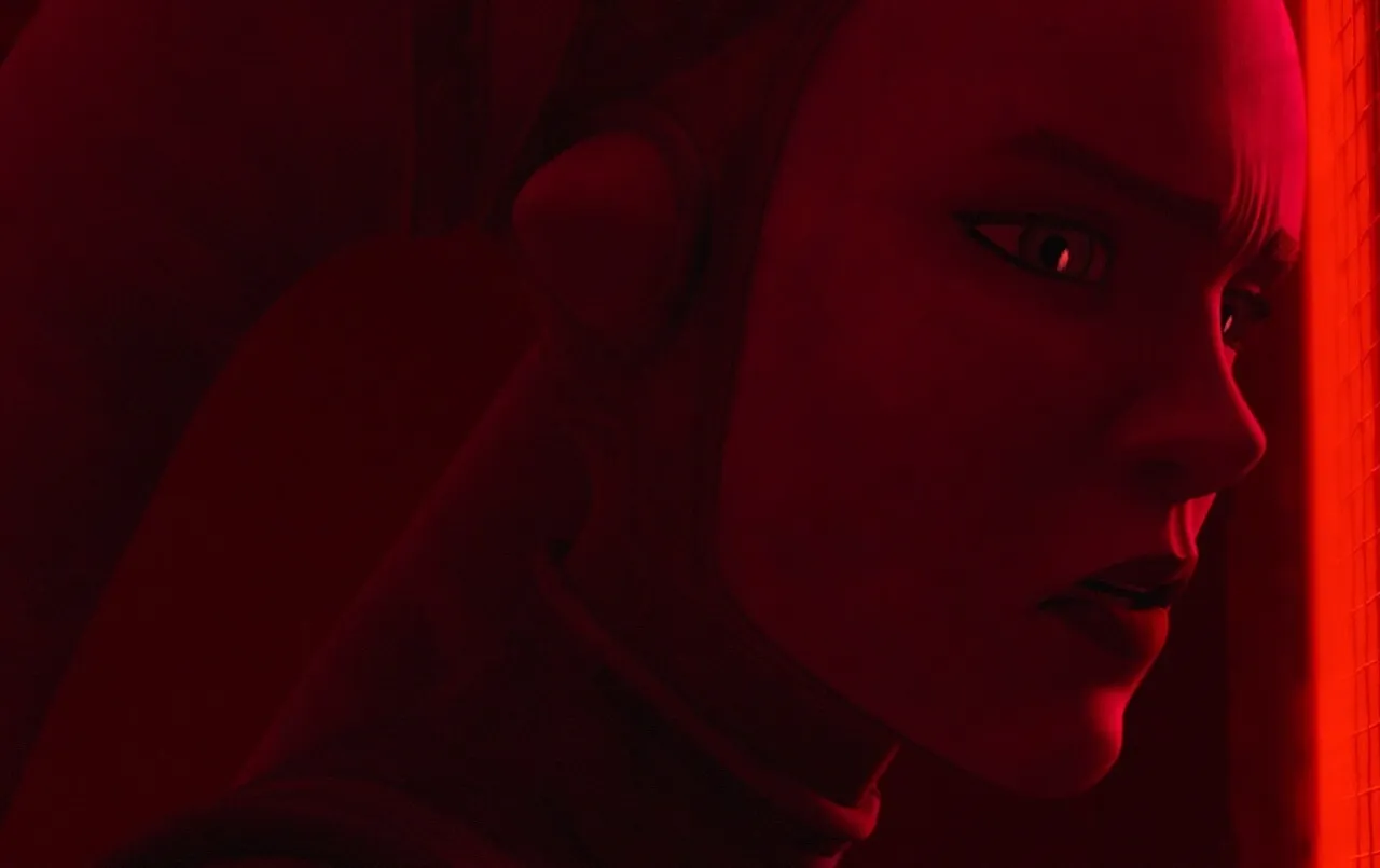 An alien female with a focused expression is bathed in a red light, suggesting a tense or dramatic scene.