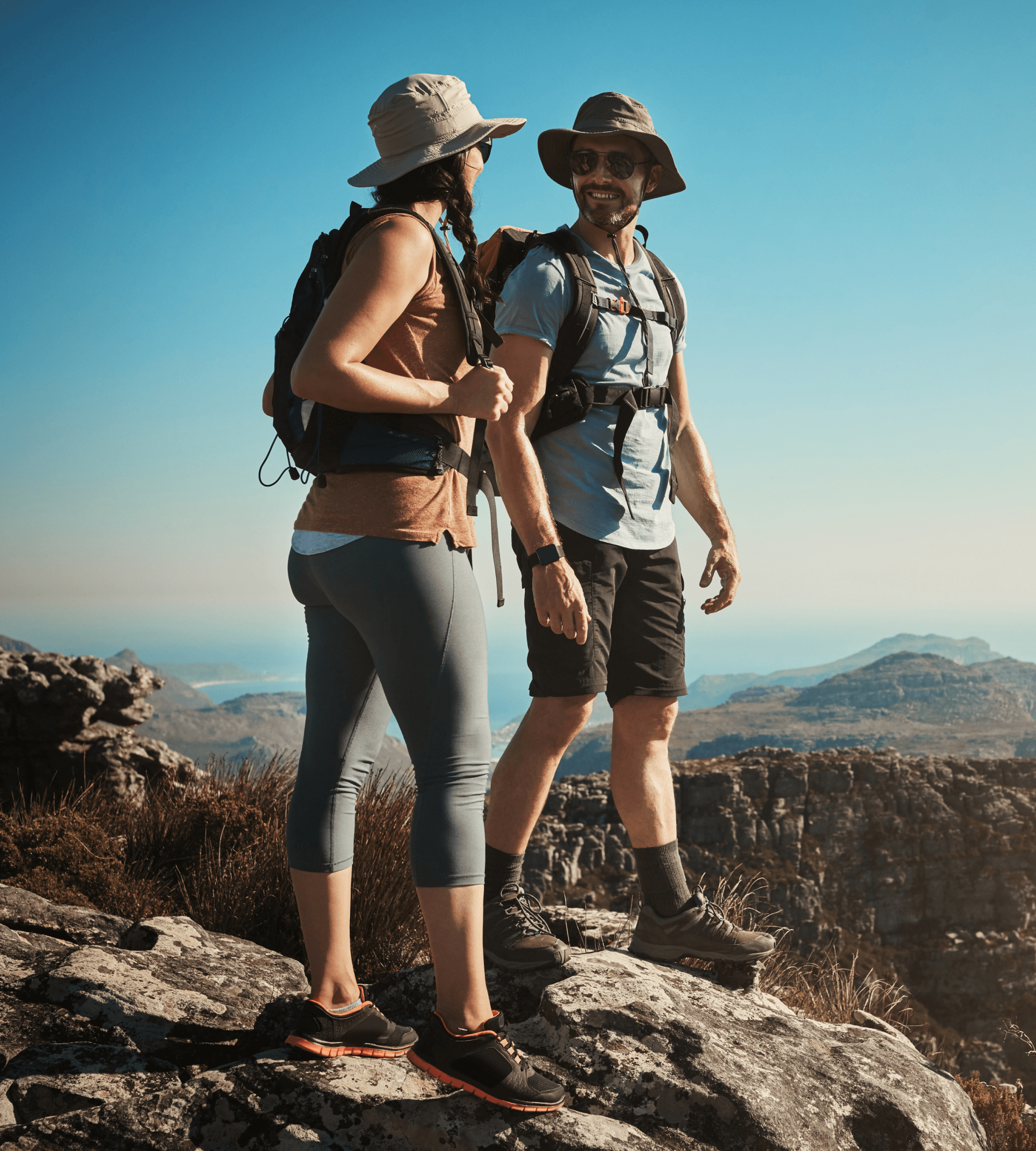 Two hikers standing on a rocky mountain trail.