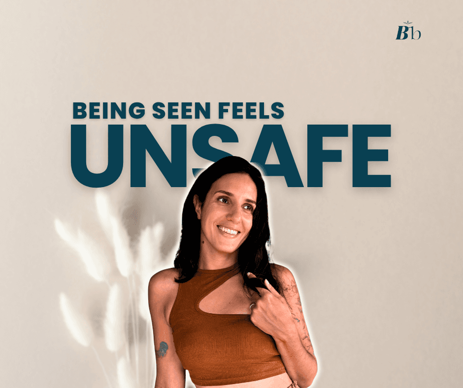 A woman is standing, smiling, staring at the top right corner, She is playing with her hair in a slightly tense mode. The caption reads "Being seen feels UNSAFE"