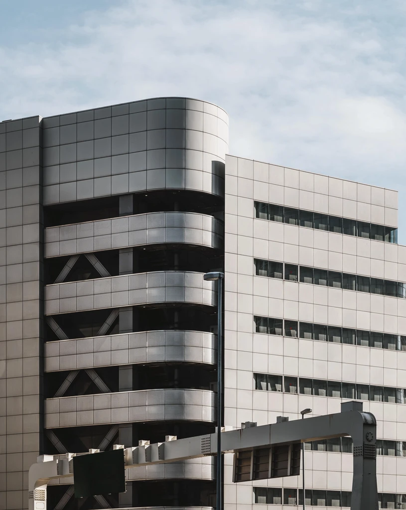 Prédio comercial cinza e um céu com nuvens